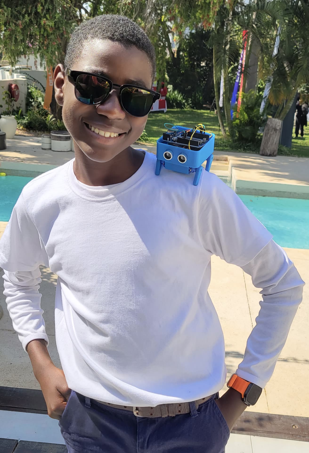 A student wearing a small 3D-printed robot built at an EO Robotics workshop